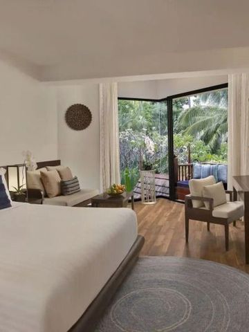 Lichtdurchflutetes Zimmer mit offenem Balkon und Gartenblick.