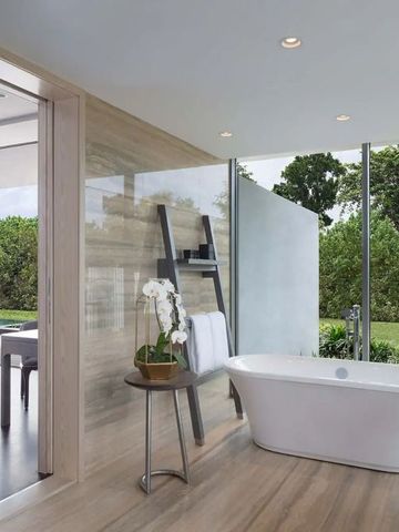 Modernes Badezimmer mit freistehender Badewanne und Gartenblick