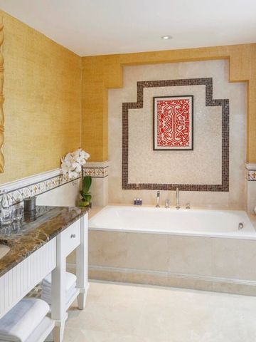 Elegantes Badezimmer mit großer Badewanne und kunstvoller Wanddekoration