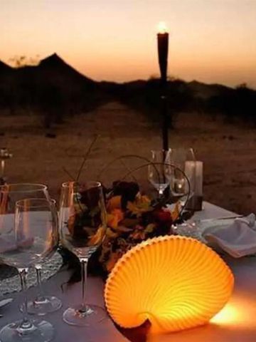 Romantisches Abendessen im Freien bei Sonnenuntergang