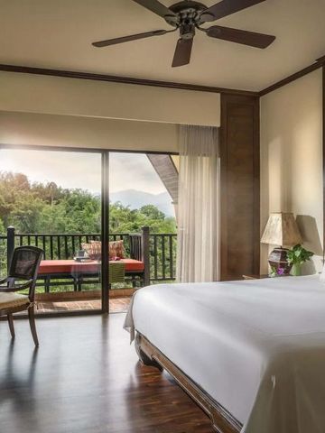 Helles Schlafzimmer mit Blick auf grüne Landschaft und privatem Balkon