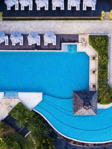 Vogelperspektive auf großen Außenpool mit Sonnenschirmen