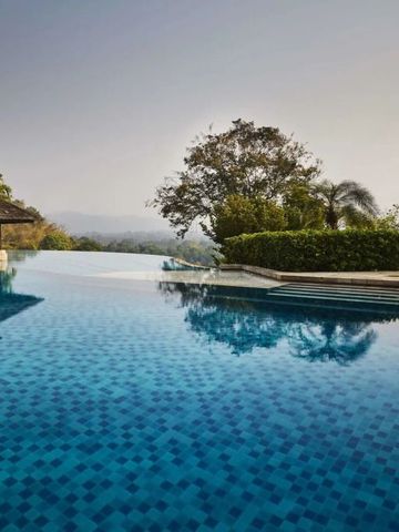 Infinity-Pool mit Blick auf Hügel und Bäume im Resort