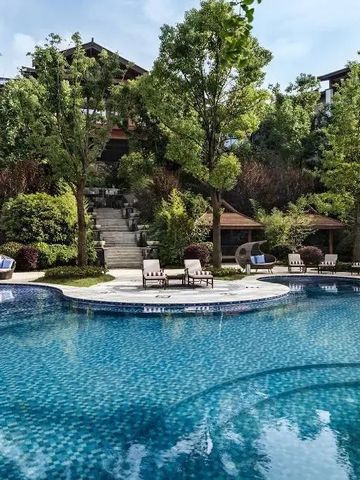 Großer Außenpool umgeben von grüner Landschaft