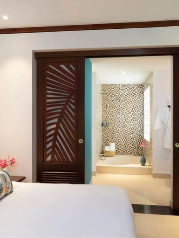 Geräumiges Schlafzimmer mit modernem Bad im Hintergrund im Anantara Hoi An Resort