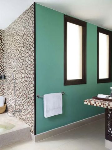 Modernes Badezimmer mit grüner Akzentwand und Mosaikfliesen in Hoi An