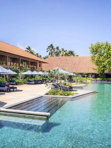 Großer Outdoor-Pool mit Sonnenliegen und Palmen im Anantara Kalutara Resort