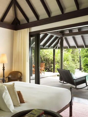 Schlafzimmer mit Blick auf eine Terrasse mit Pool und tropischen Pflanzen