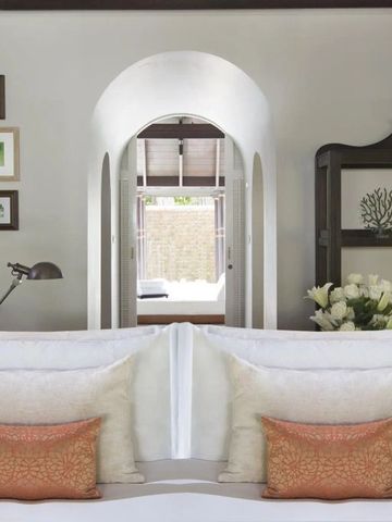 Detailaufnahme eines Bettes mit dekorativen Kissen und Blumen