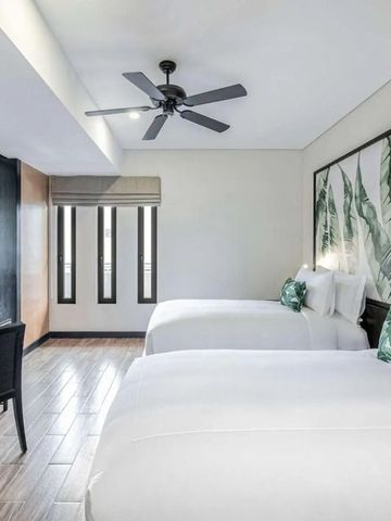 Zweibettzimmer mit modernem Dekor und Pflanzenmotiv an der Wand