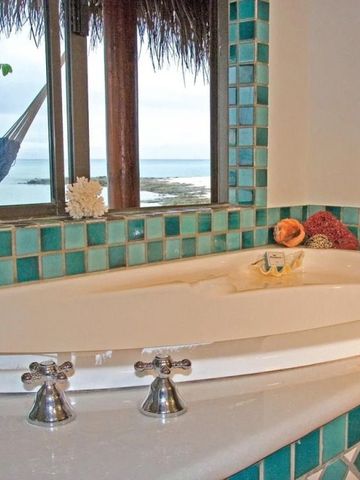 Luxuriöse Badewanne mit Ausblick auf das Meer und eine Hängematte