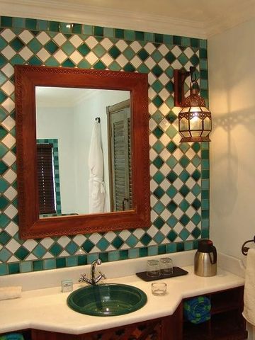 Badezimmer mit Spiegel und dekorativen Fliesen in Blau und Grün