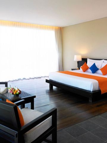 Modern eingerichtetes Hotelzimmer mit großem Bett und Sitzbereich