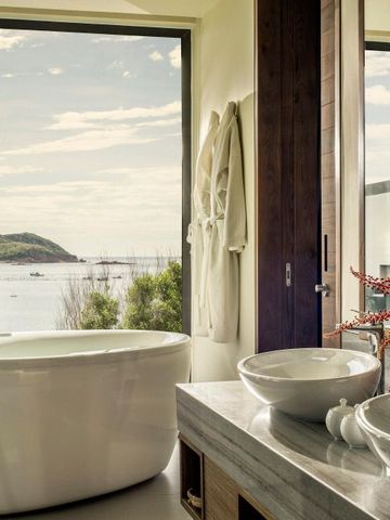 Luxuriöses Badezimmer mit freistehender Badewanne und Meerblick