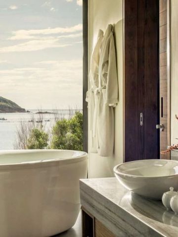 Hochwertiges Badezimmer mit Meerblick und freistehender Badewanne