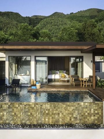 Luxuriöse Villa mit privatem Pool und grüner Bergkulisse im Hintergrund.