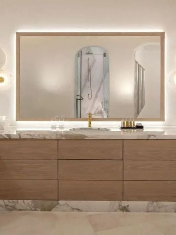 Modernes Badezimmer mit Marmordetails und großen Spiegeln