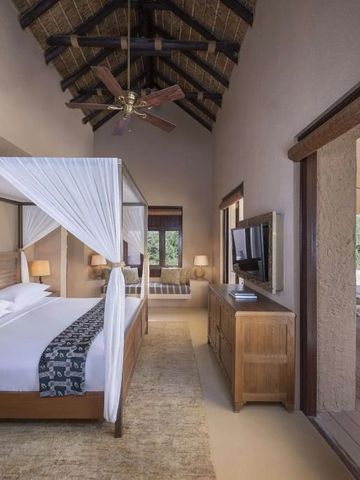 Großzügiges Schlafzimmer mit Himmelbett und Zugang zu privater Terrasse im Resort