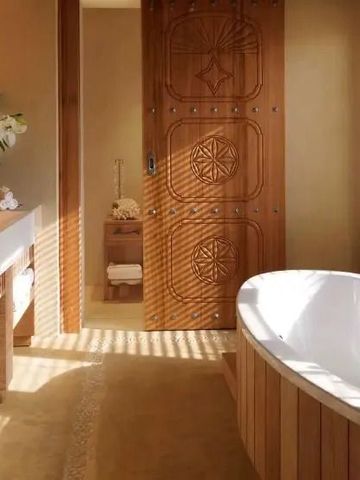 Luxuriöses Badezimmer mit Badewanne und eleganten Holzdetails im Resort