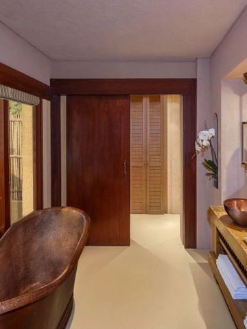 Luxuriöses Badezimmer mit Holzbadewanne und eleganten Armaturen