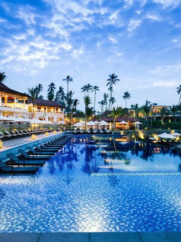 Infinity-Pool am Abend mit beleuchteten Palmen und Sonnenliegen im Anantara Resort