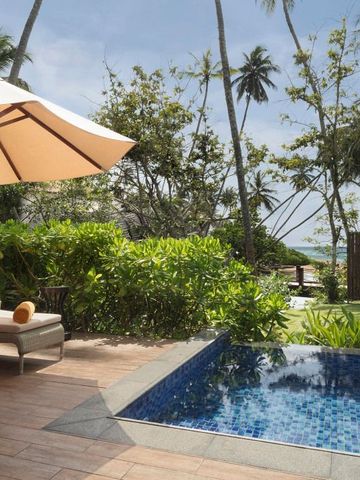 Private Terrasse mit kleinem Pool und Liegestühlen umgeben von tropischem Grün