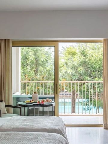 Helles Zimmer mit Balkon und Blick auf Pool und Garten