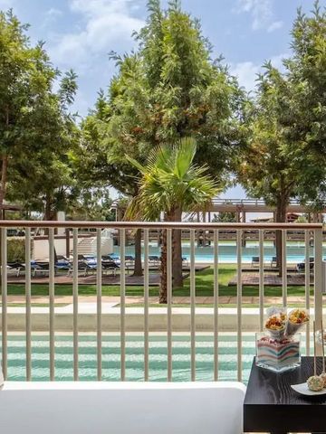 Balkon mit Sicht auf den Pool und grüne Gartenlandschaft