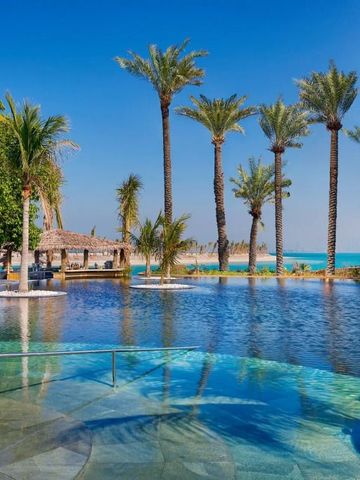 Infinity Pool umgeben von Palmen mit Blick auf das Meer