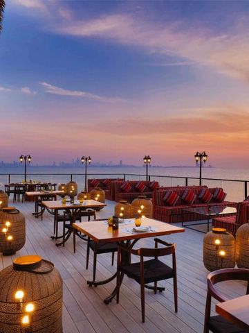 Romantische Dachterrasse bei Sonnenuntergang mit Kerzen und Meerblick
