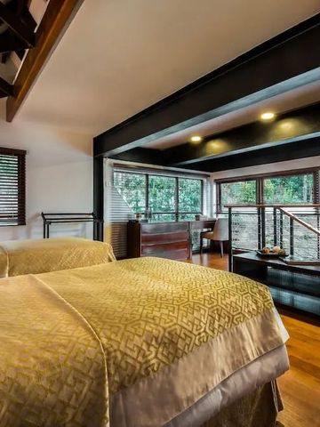 Luxuriöses Schlafzimmer mit großen Fenstern und Blick ins Grüne im Anasa Wellness Resort