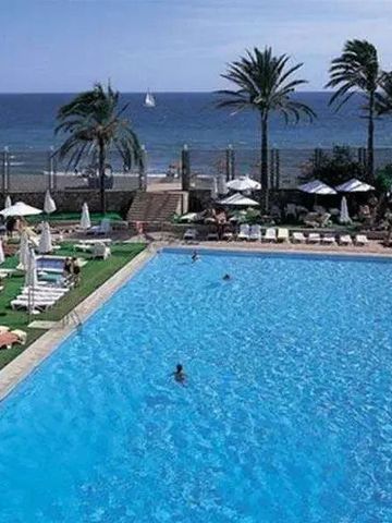 Großer Außenpool mit Liegestühlen und Blick auf das Meer