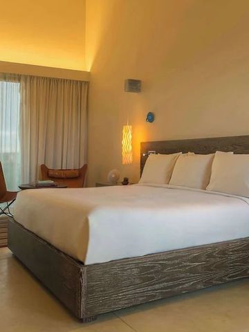 Modernes Hotelzimmer mit großem Bett und gemütlichem Sitzbereich.