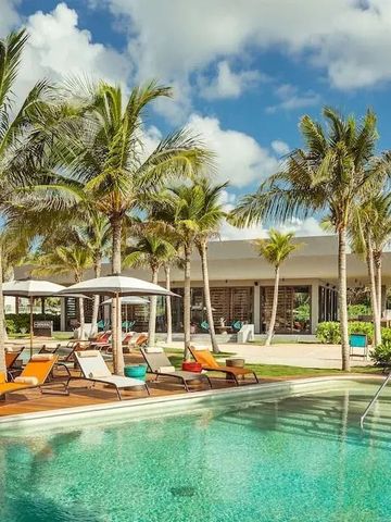 Großer Pool mit Liegestühlen und Palmen, sonnige Anlage.