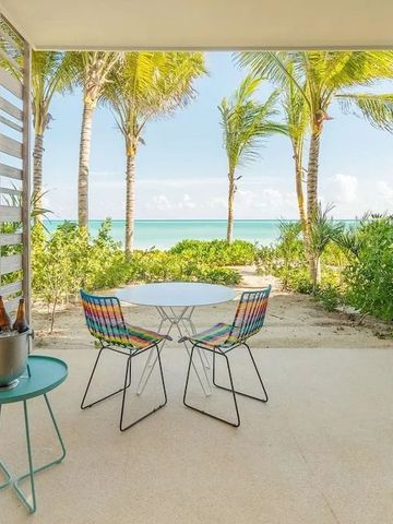 Terrasse mit bunten Stühlen, Blick auf das Meer und Palmen