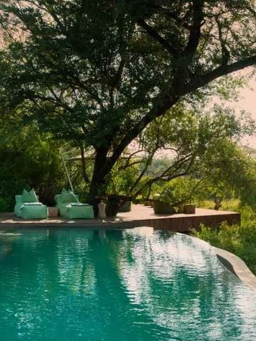 Infinity-Pool umgeben von üppiger Natur mit Blick auf die atemberaubende Landschaft.
