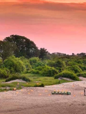Weite Landschaft bei Sonnenuntergang mit romantischer Atmosphäre im Ngala Tented Camp.