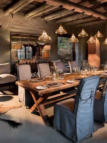 Elegantes Esszimmer mit großem Holztisch und stilvoller Beleuchtung.