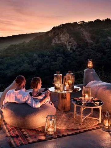 Romantische Terrasse mit Paar bei Sonnenuntergang und Laternenbeleuchtung