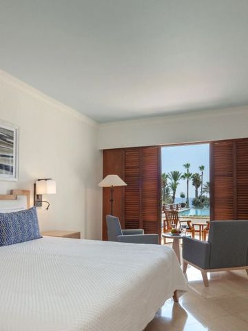 Hotelzimmer mit Blick auf Palmen und das Meer