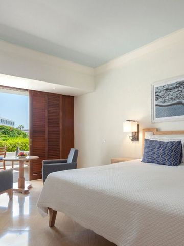 Geschmackvoll eingerichtetes Hotelzimmer mit Balkon und Gartenblick