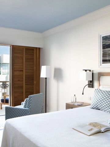 Helles Hotelzimmer mit Balkon und modernen Möbeln