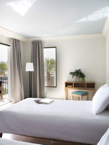 Hotelzimmer mit Doppelbetten und Balkon mit Meerblick