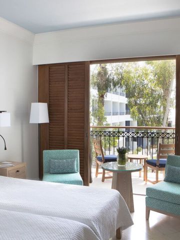 Lichtdurchflutetes Zimmer mit Balkon und stilvollen Sesseln