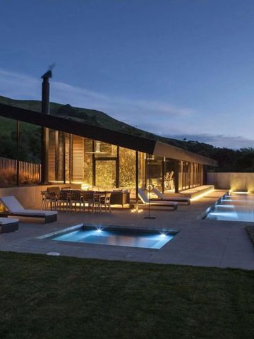 Moderne Außenansicht bei Nacht mit beleuchtetem Poolbereich