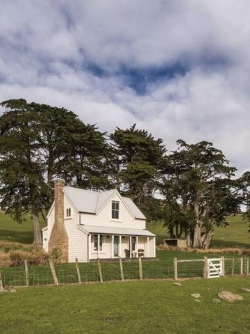 Romantisches Landhaus umgeben von Bäumen und Wiesenlandschaft