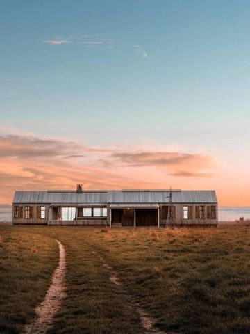 Moderne Holzvilla in ländlicher Umgebung bei Sonnenuntergang