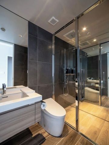 Modernes Bad mit verglaster Duschkabine und WC in zeitgemäßem Design.