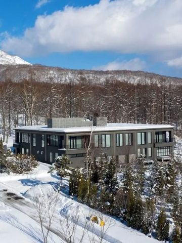 Schneebedecktes Hotelgebäude in winterlicher Landschaft mit Bergen.