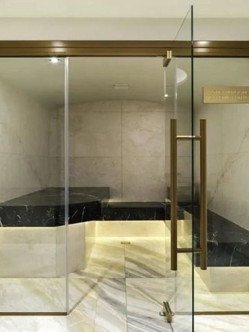 Moderne Sauna mit Glaswänden und schwarzem Marmordesign